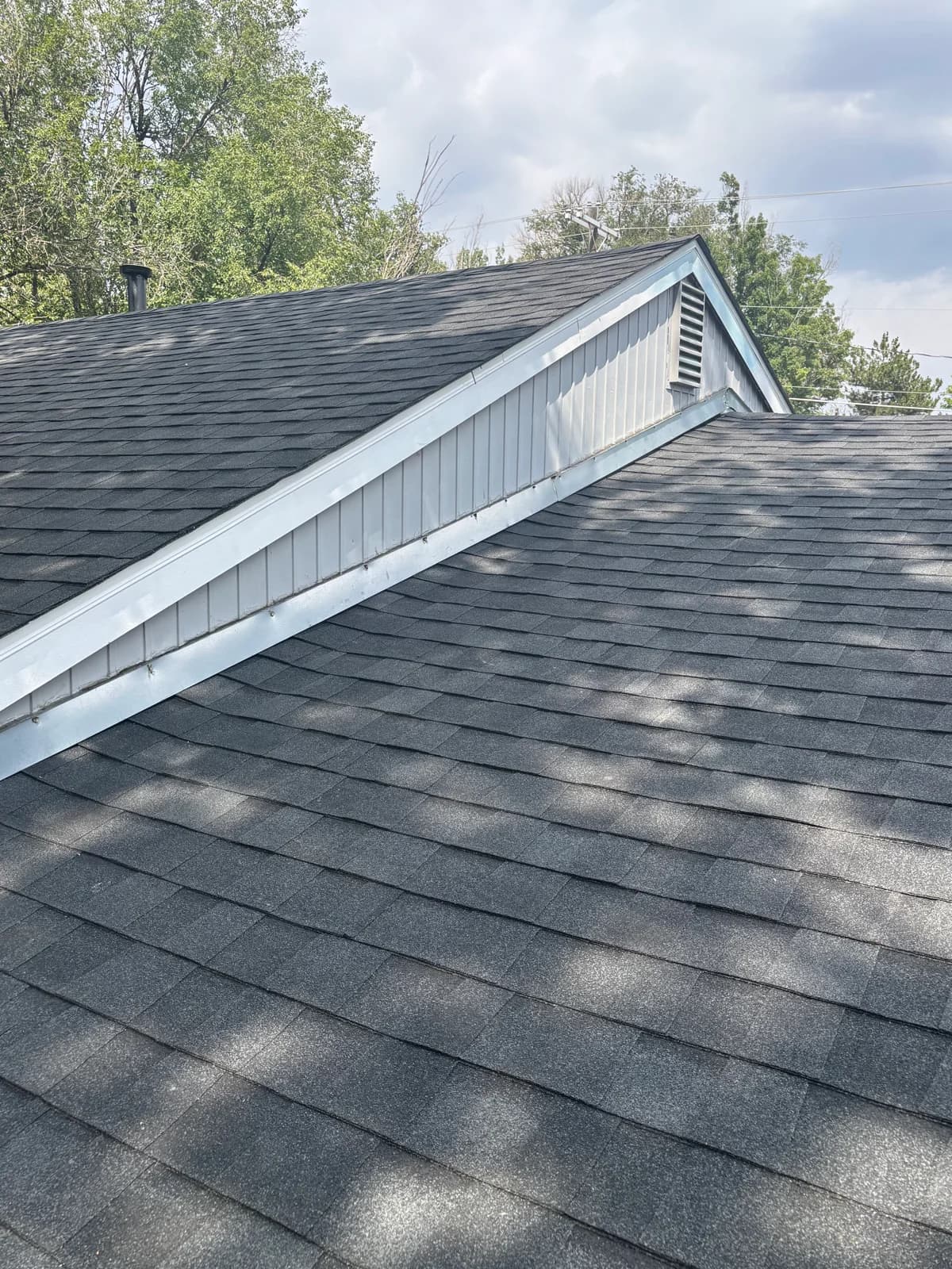 Shingle roof planes meeting a white gable